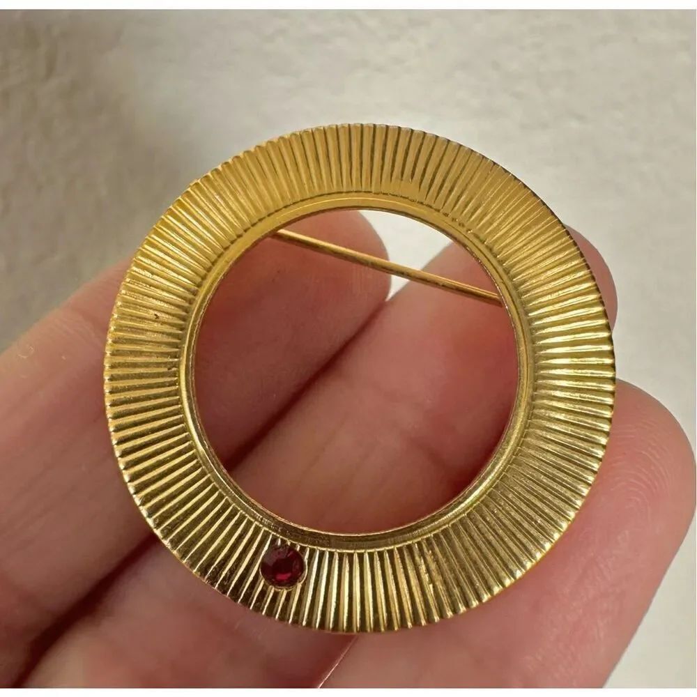 Gold tone vintage round brooch with red rhinestone